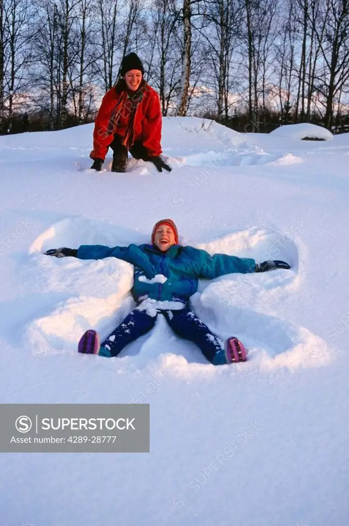 Woman & boy Making Snow Angles Anchorage SC AK Winter