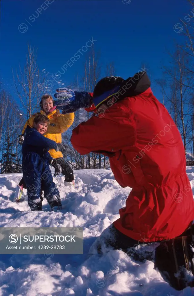 Family throwing snowballs Russian Jack Park Anchorage SC AK winter scenic
