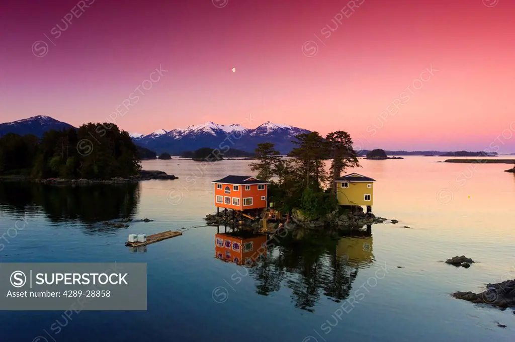 Waterfront houses in early morning with the moonrise over the harbor in Sitka, Alaska