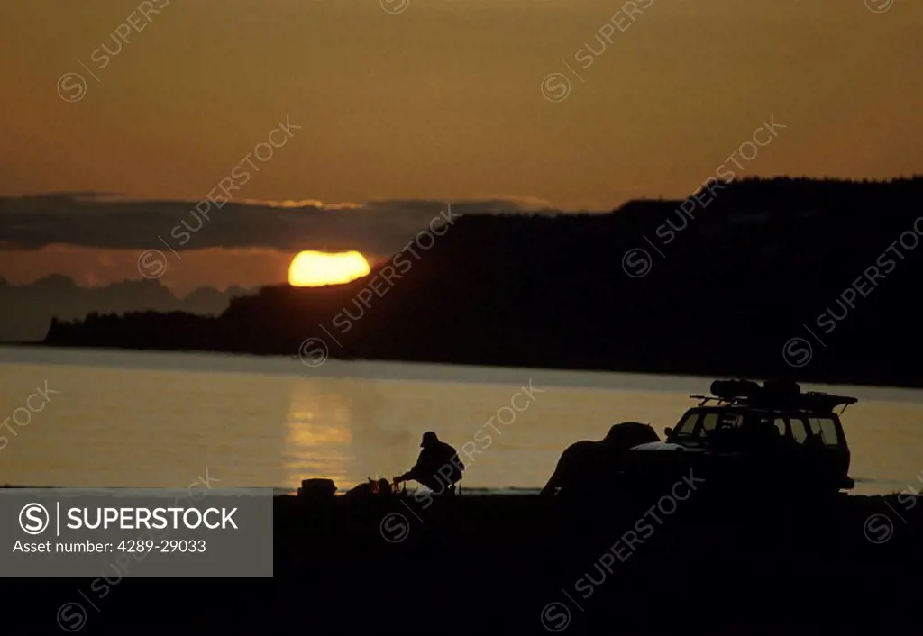 Sunset Silhouette of Campers Kachemak Bay Homer KP AK/nCampfire & vehicle