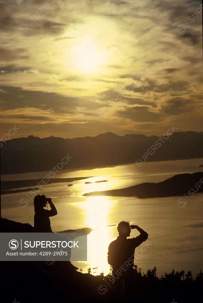Couple viewing sunset Inside Passage near Juneau SE AK summer scenic
