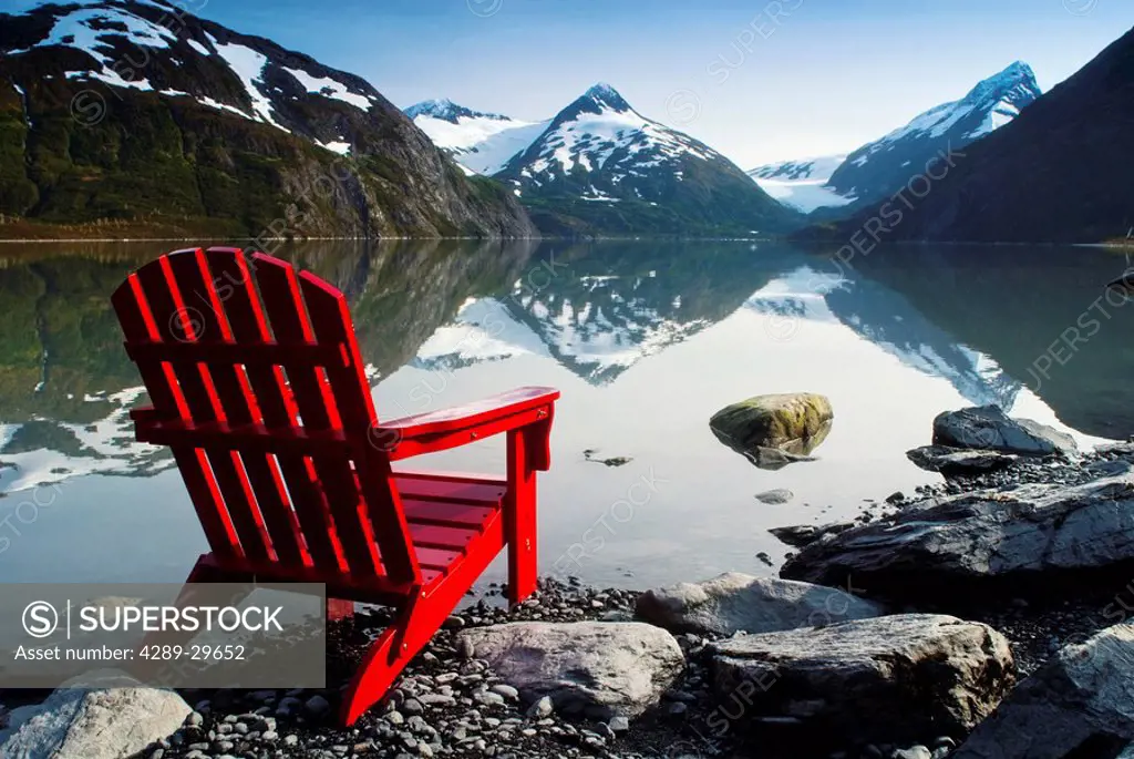 Red Adirondack chair at Portage Lake with Chugach Mountains in the background, Southcentral, Alaska