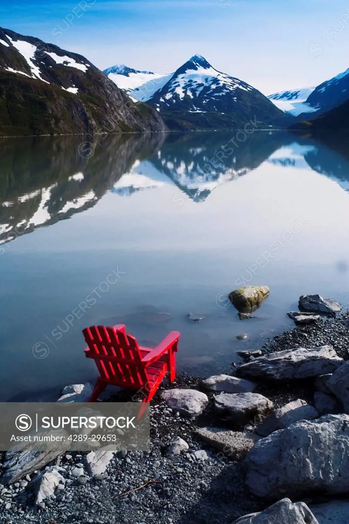 Red Adirondack chair at Portage Lake with Chugach Mountains in the background, Southcentral, Alaska