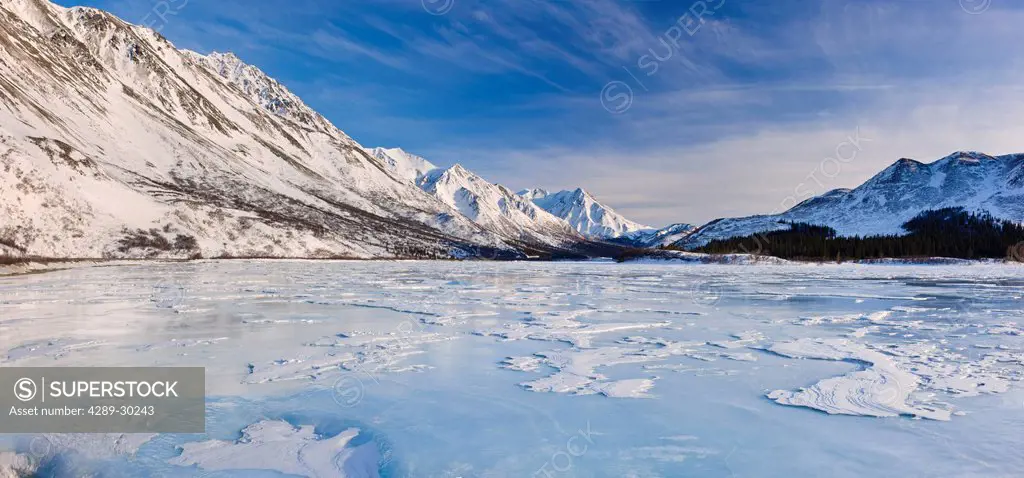 View of sastrugi wind carved ridges in the snow covering frozen Phelan Creek alongside the Richardson Highway as it heads into the Alaska Range, South...