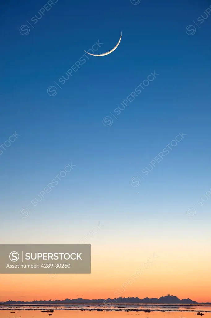 Cresent moon rising at sunset over Cook Inlet near Elderberry Park in Anchorage, Southcentral Alaska, Winter, COMPOSITE