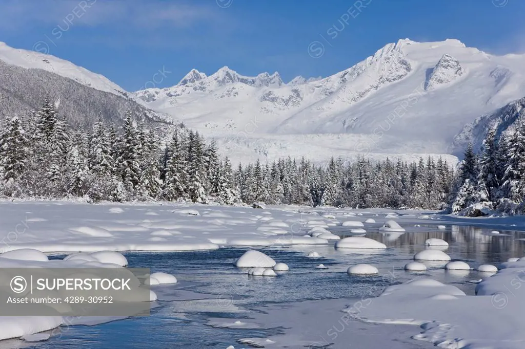 Scenic Winter view of Mendenhall River nearly frozen over with Mt. McGinnis and Stroller White mountain in the background, Southeast Alaska