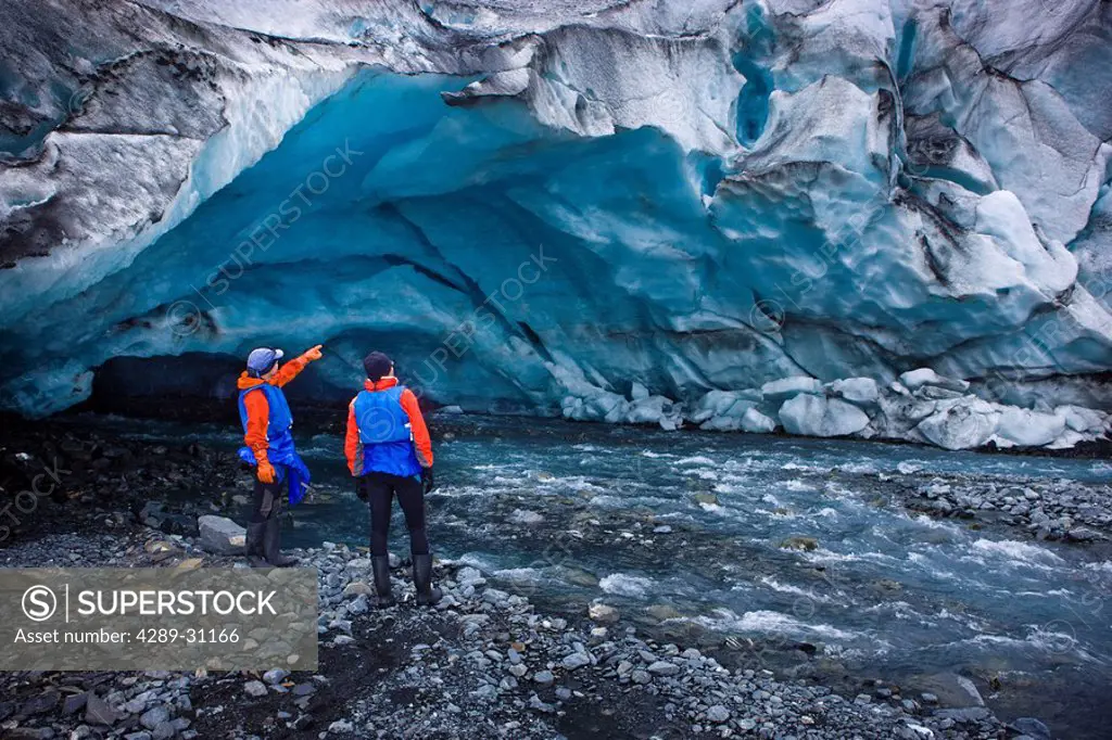 Male & female kayakers explore an ice cave in front of Shoup Glacier, Shoup Bay State marine Park, Prince William Sound, Southcentral Alaska