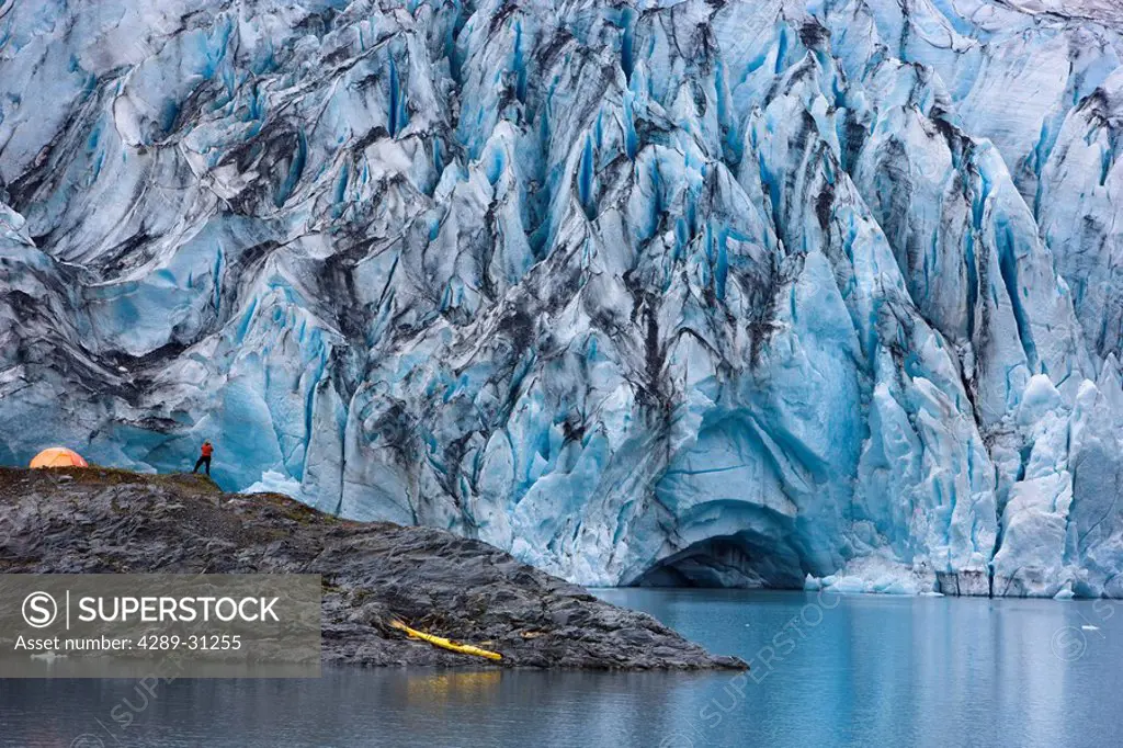 Kayaker with his boat pulled up on an island in front of Shoup Glacier, Shoup Bay State Marine Park, Prince William Sound, Southcentral Alaska