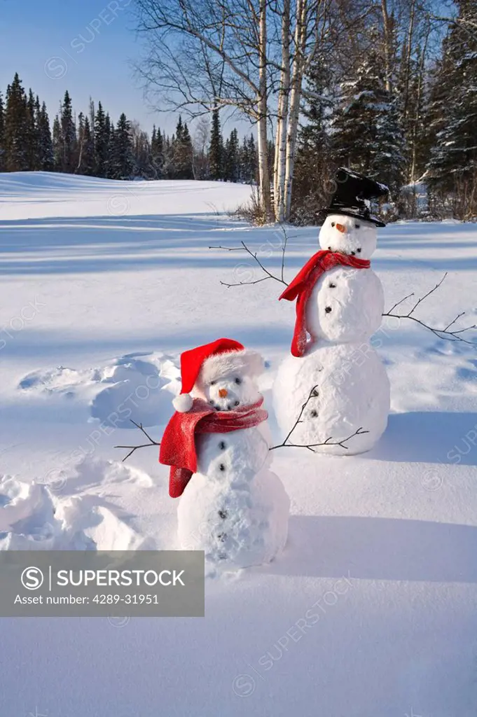 Snowmen in forest after making snow angel imprint in snow Alaska Winter