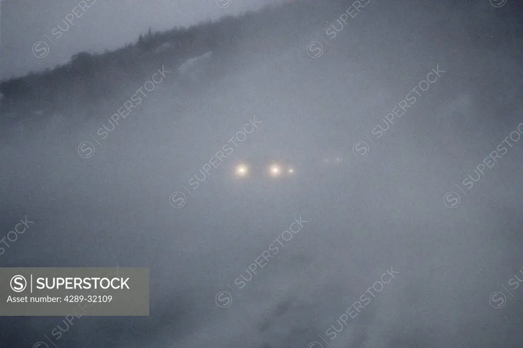 Vehicles in snowstorm driving on road SC AK winter scenic