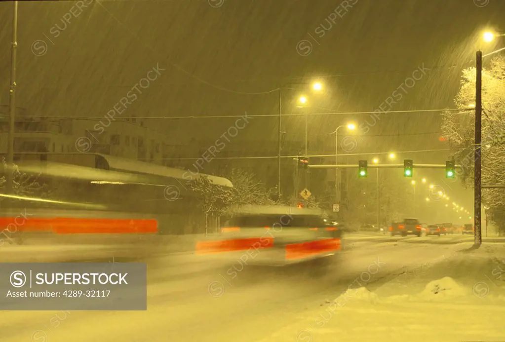 Cars Driving City Street Snowing Winter Night ANC AK Southcentral Blurred