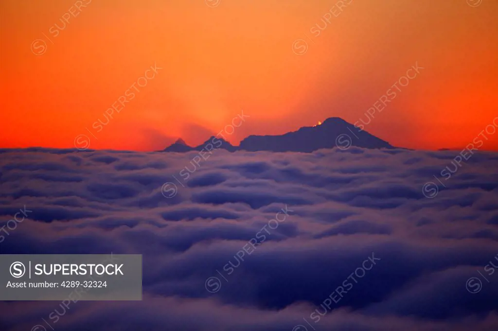 Mt. Iliamna at sunset with a fog covered Cook inlet in the foreground, Anchorage, Alaska, Southcentral,