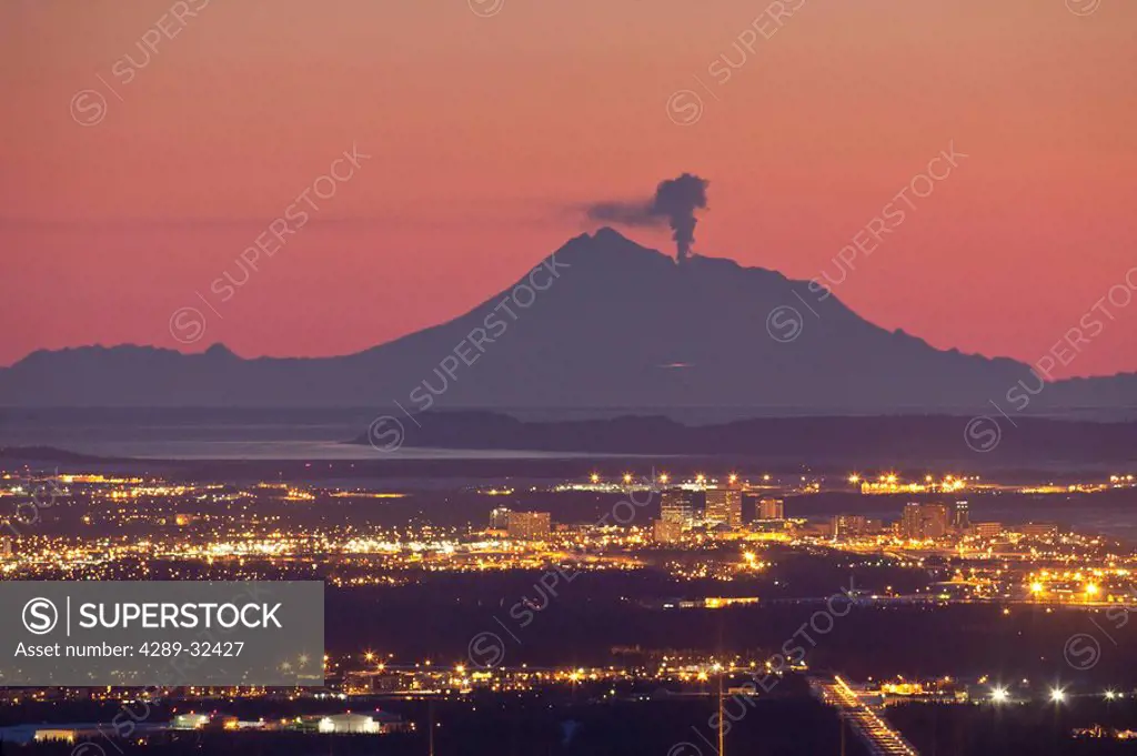 View of minor eruption of ash and steam from Mt. Redoubt with Anchorage, Alaska in the foreground during Winter
