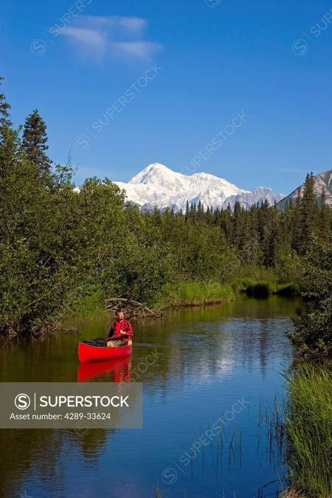 Man Canoeing on Byers lake with Denali in the background Southcentral Alaska Summer