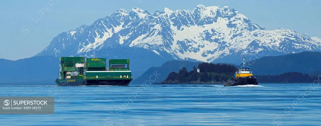 A tug pulling a barge cruises through the Inside Passage on its way south from Skagway, Alaska. Lynn Canal, Alaska Marine Lines.