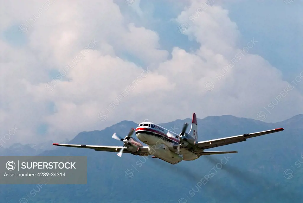 Convair Model 340 twin engine aircraft takes off from Palmer Municipal Airport with Chugach Mountains in the background, Matanuska_Susitna Valley, Sou...