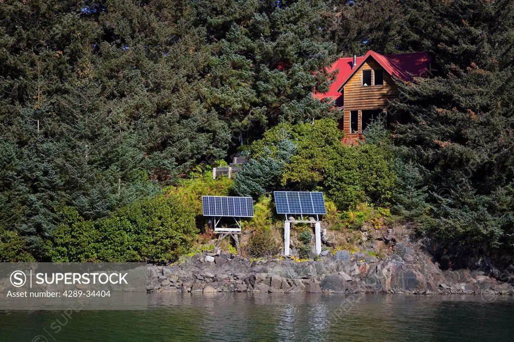 Scenic view of a log home powered by solar panels in Anton Larsen Bay, Kodiak Island, Southwest Alaska, Summer