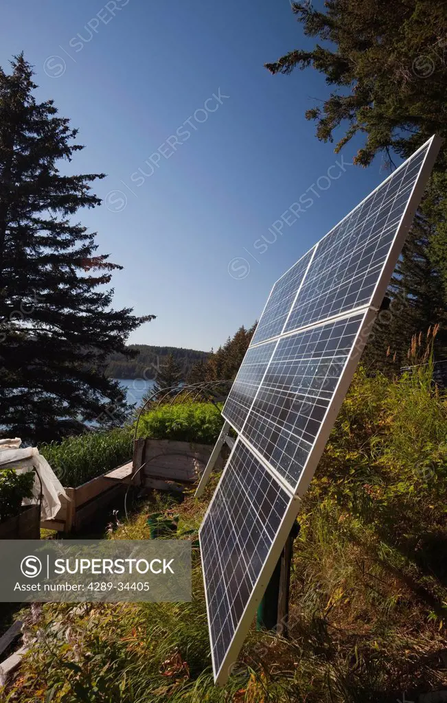Close up of solar panels installed near a residential log cabin along the coastline, Kodiak Island archipelago, Southwest Alaska, Summer