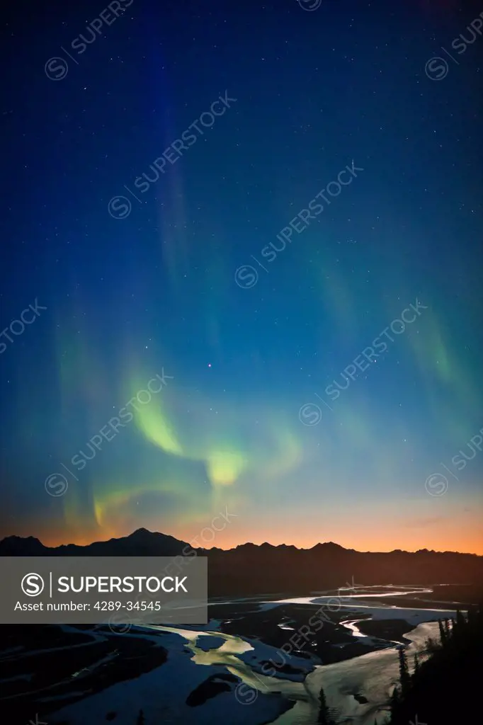 View of Northern Lights in the sky above southside Mount McKinley and the Alaska Range at twilight, Chulitna River in the foreground, Denali State Par...