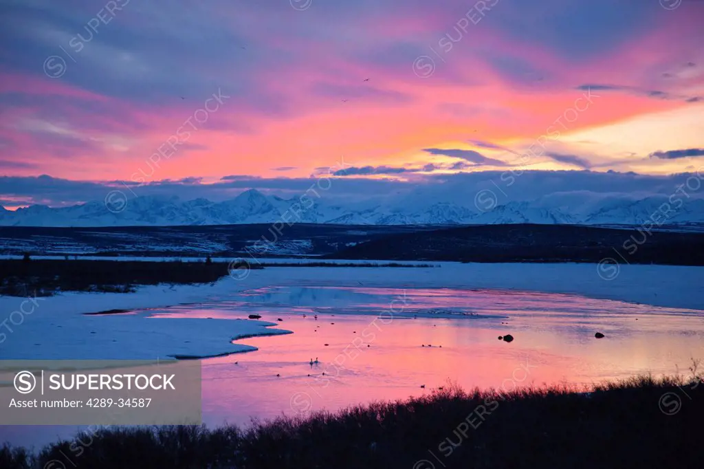 View of sunset reflected in Summit Lake with Alaska Range in the background, Paxon, Southcentral Alaska, Spring