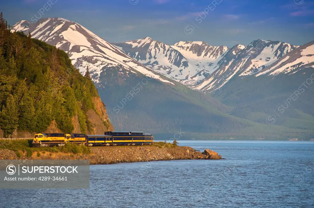 An Alaska Railroad passenger train rounds a corner along Turnagain Arm near Bird Creek, Southcentral Alaska, Summer