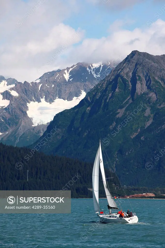 People sailing in Resurrection Bay near Seward with Kenai Mountains in the background, Southcentral Alaska, Summer