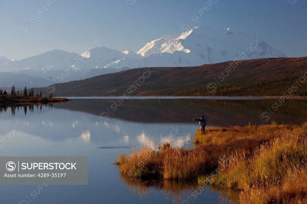 Fly fisherman casting over Wonder lake with the northside of Mt. McKinley in the background, Denali National Park and Preserve, Interior Alaska, Fall