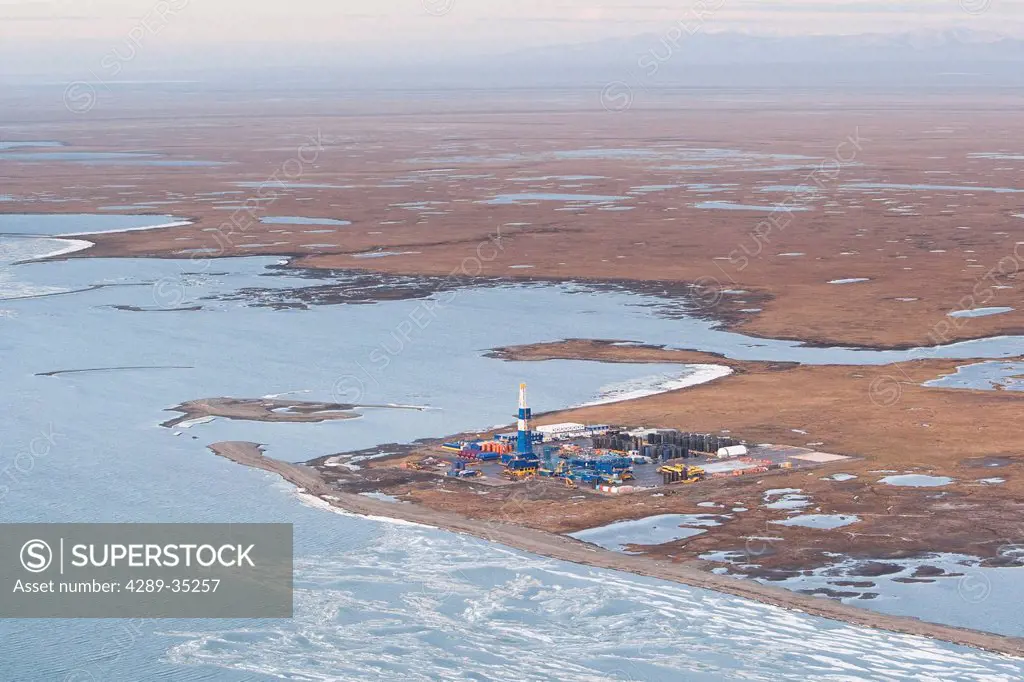 Aerial view of an oil well drilling platform on the tundra at the edge of the Beaufort Sea, Arctic Alaska, Summer