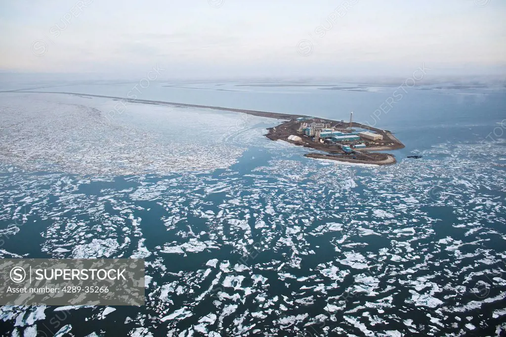 Aerial view of an oil well drilling platform on a man_made island and surrounded by broken sea ice, Prudhoe Bay, Beaufort Sea near Deadhorse, Arctic A...