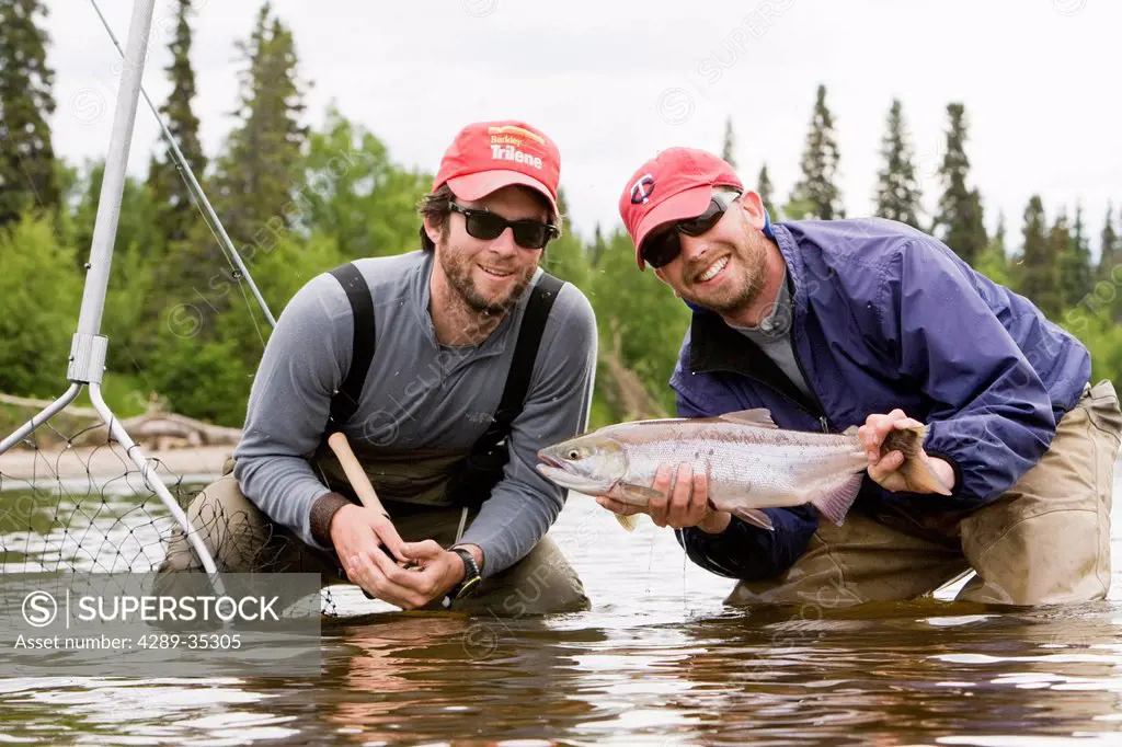 Two fly fishermen hold their caught Sockeye salmon, Koktuli River in the Bristol Bay area, Southwest Alaska, Summer