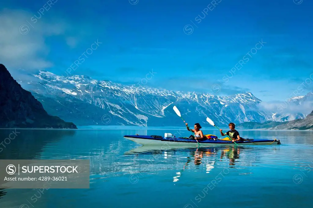 Sea kayakers paddling in Muir Inlet on a sunny day, Glacier Bay National Park & Preserve, Southeast Alaska, Summer