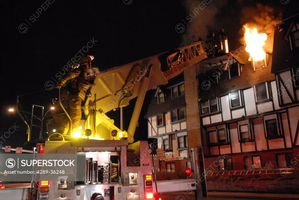 Members of the Anchorage Fire Department work during a cold winter night to extinguish a blaze at the King´s Court apartment building near downtown, S...