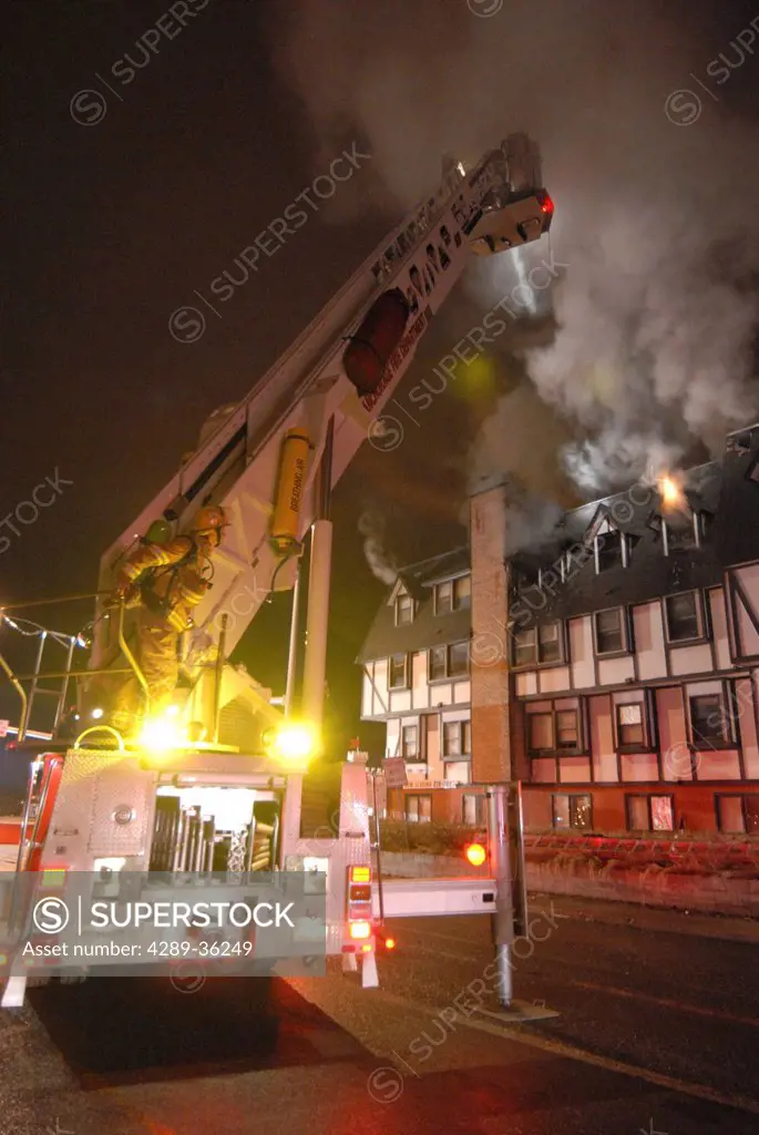 Members of the Anchorage Fire Department work during a cold winter night to extinguish a blaze at the King´s Court apartment building near downtown, S...