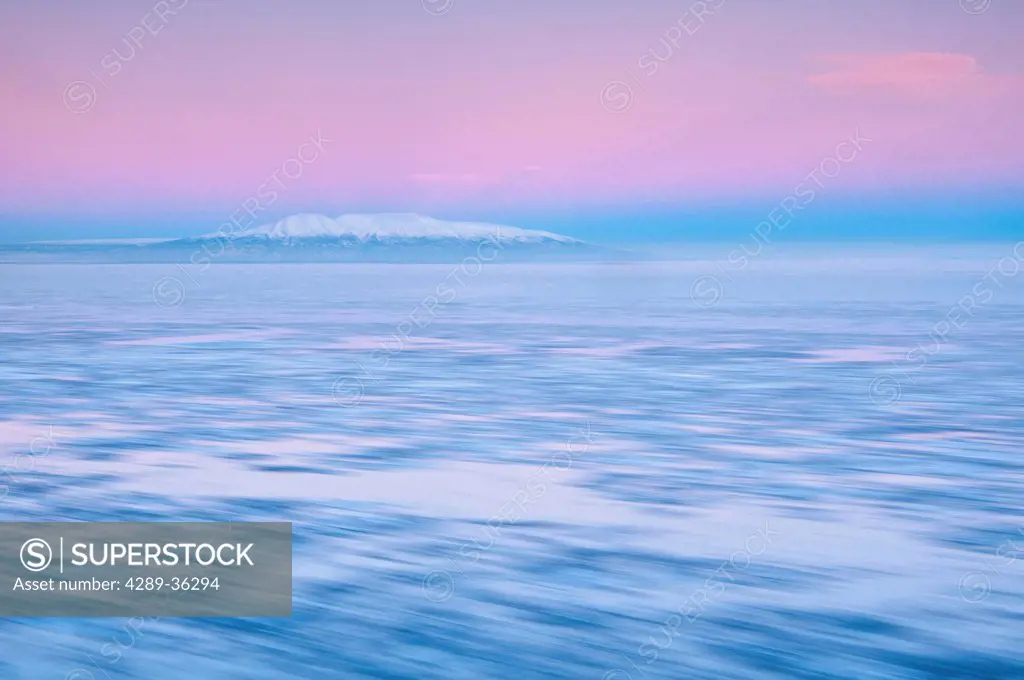 Blurred motion view of outgoing tide and ice at sunrise with Mt. Susitna in the background, Point Woronzof, Anchorage, Southcentral Alaska, Winter
