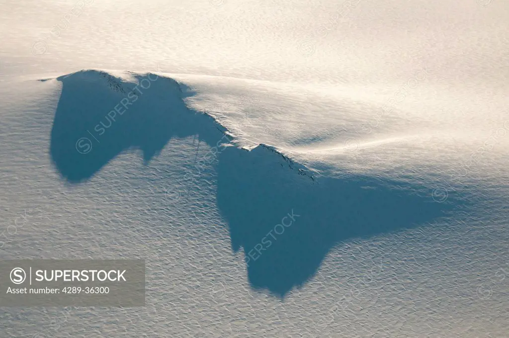 Long shadows cast from a nunatak and radio tower on the Harding Ice Field in Kenai Fjords National Park, Southcentral Alaska, Winter