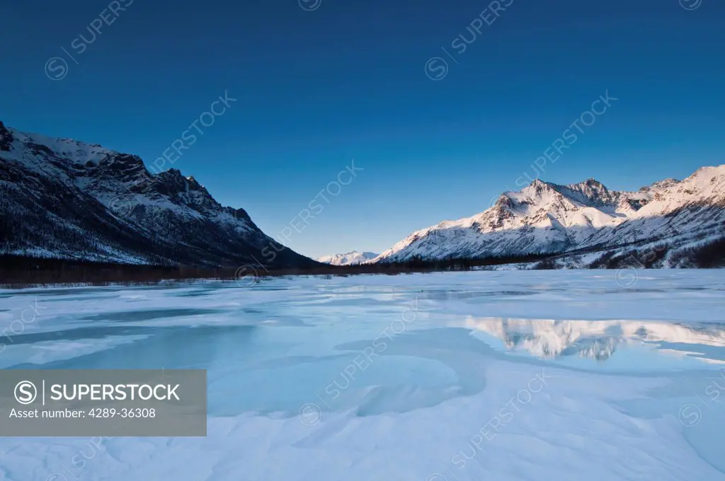 Alpenglow on Boreal Mountain reflects on overflow ice on the North Fork of the Koyukuk River in Gates of the Arctic National Park & Preserve, Arctic A...