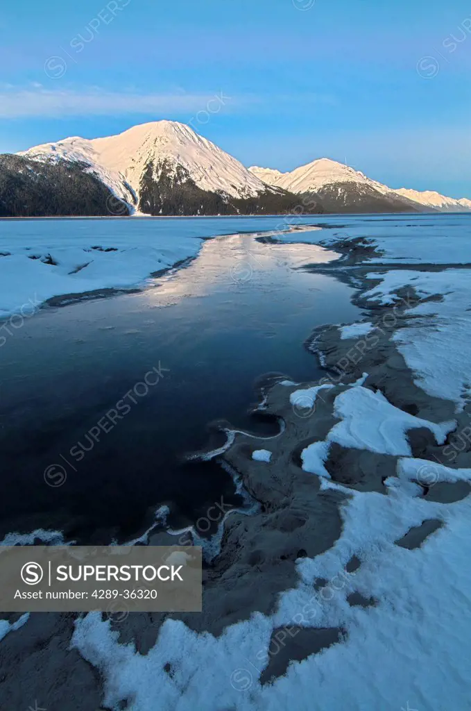 Morning light on the Kenai Mountains reflects on the waters and ice of Turnagain Arm, Southcentral Alaska, Winter. HDR