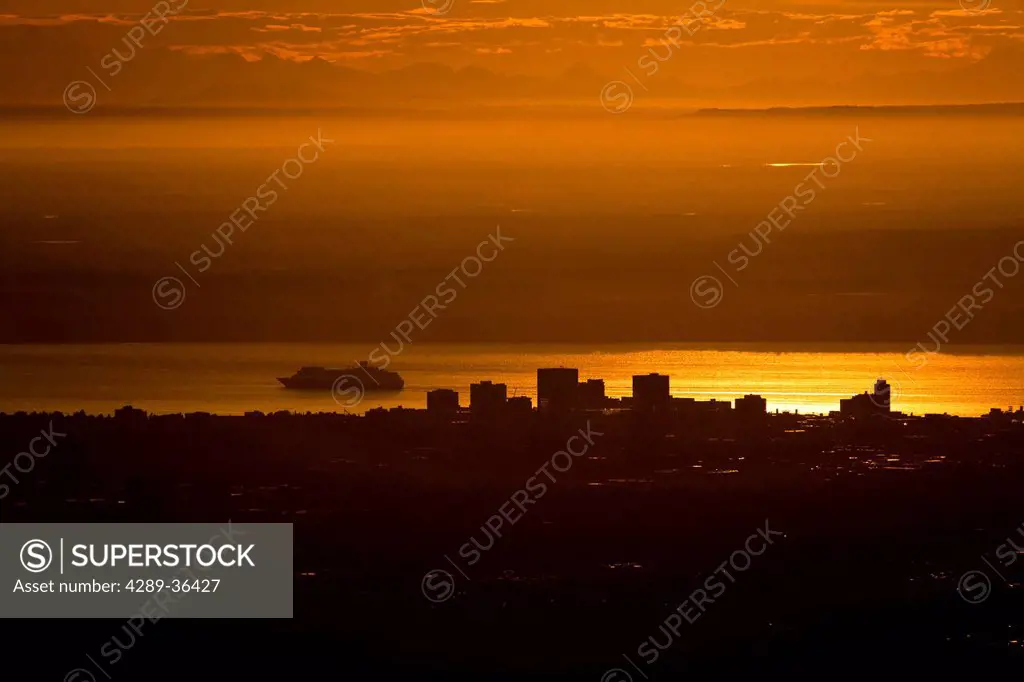 View of downtown Anchorage and a departing cruise ship in Cook Inlet with the Alaska Range in the background at Sunset, Southcentral Alaska, Summer