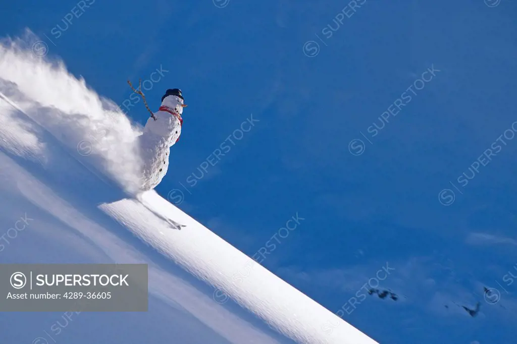 Snowman skiing down ridgeline in Talkeetna Mountains, Southcentral Alaska, Winter. Composite