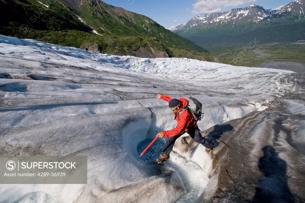 Man Traversing Exit Glacier Near Seward, Alaska On A Sunny Afternoon In Summer