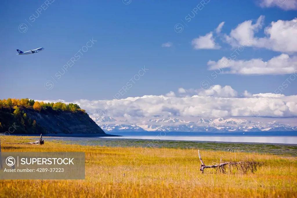 Plane Taking Off From Ted Stevens International Airport And Flying Above Point Wornzof, Alaska Range In The Background, Anchorage, Southcentral Alaska