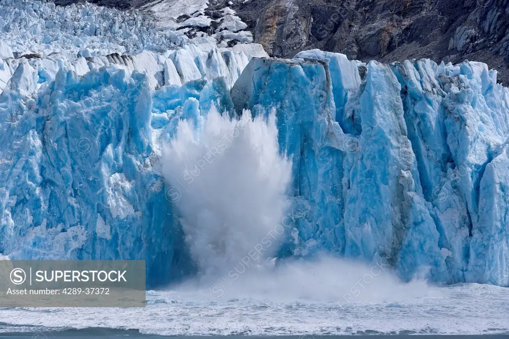 A spray of water explodes skywards as a portion of Dawes Glacier is calved into the sea, Southeast Alaska, Inside Passage, Summer