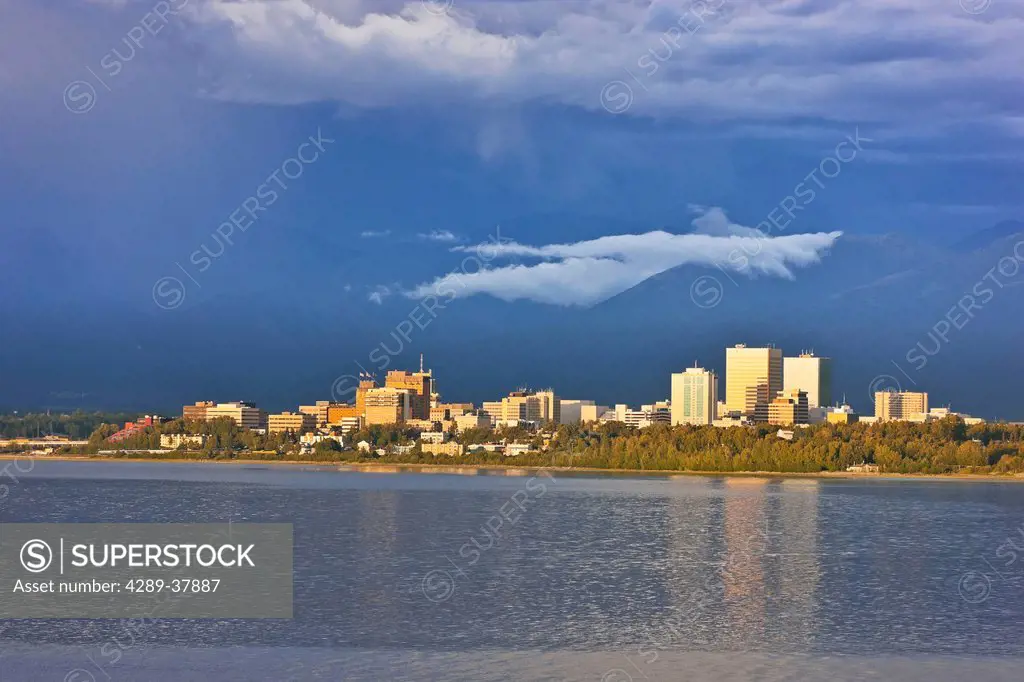 Thunderclouds Above The Anchorage City Skyline And Knik Arm At High Tide, Chugach Mountains In The Background, Southcentral Alaska, Summer