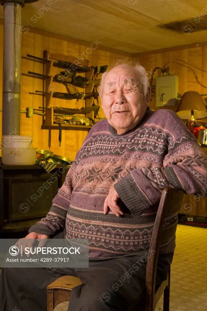Portrait Of Native Male Yupik Elder Sitting In Living Room Akiachak Western Alaska Indoors