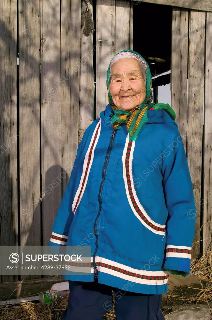 Elder Native Yupik Woman Outside Standing In Front Of His Smokehouse Akiak Western Alaska Winter