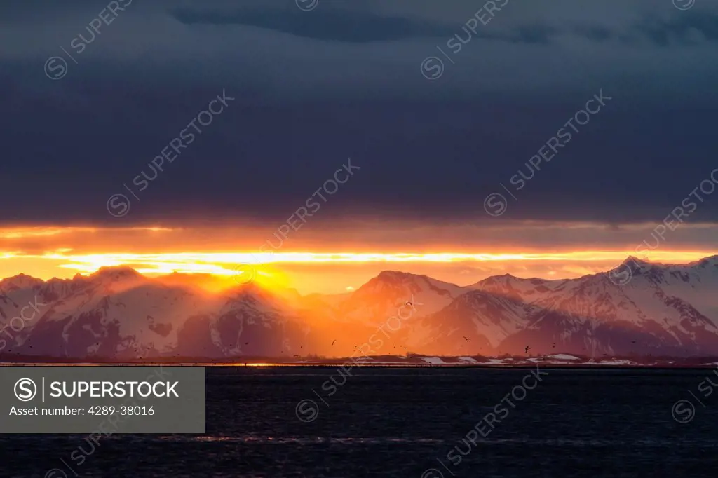 A Colourful Sunset Below A Cloud Bank Over The Chugach Mountains During Low Tide On The Copper River Flats Salmon Fishing Grounds; Cordova Alaska Unit...