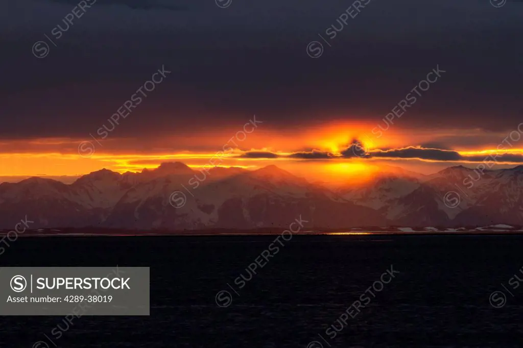 A Colourful Sunset Below A Cloud Bank Over The Chugach Mountains Turns Into A Surreal Golden Glow During Low Tide On The Copper River Flats Salmon Fis...