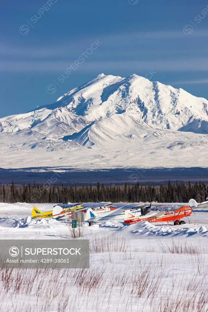 Snow Covers The Wings Of The Small Airplanes Tied Up At The Glenallen Airport Along The Richardson Highway Looking East Towards Mount Drum In Winter S...