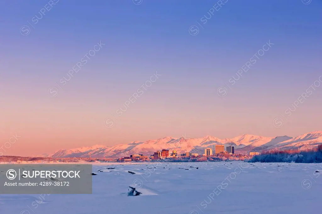 Scenic winter view of sunset over the downtown anchorage skyline and the snow covered tidal flats of knik arm;Alaska usa
