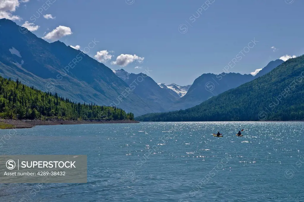 Teenage boys paddling a kayak on Eklutna Lake in Summer in Southcentral Alaska